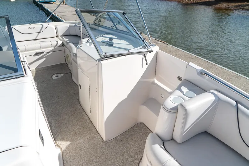 Slide: The Image of 2002 Ebbtide 2400 Mystique Fun Cruiser interior with seating, near water. - 15
