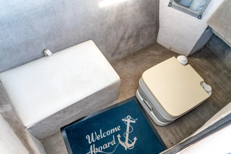 Slide: The Image of Interior of 2002 Ebbtide 2400 Mystique Fun Cruiser with welcome mat and portable toilet. - 21
