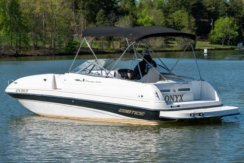 Slide: The Image of 2002 Ebbtide 2400 Mystique Fun Cruiser boat on a serene lake. - 5
