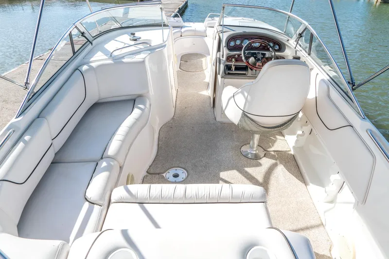 Slide: The Image of 2002 Ebbtide 2400 Mystique Fun Cruiser interior with white seating and steering console. - 7