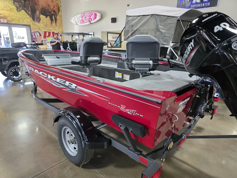 Slide: The Image of 2025 Tracker Super Guide V 16 T boat, red, with Mercury 40 HP engine, in showroom. - 12