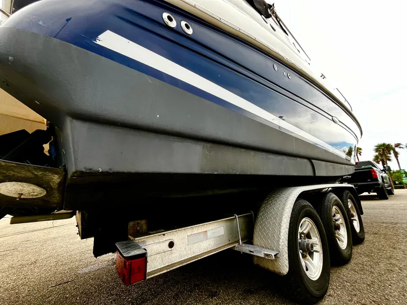 Slide: The Image of 2005 Sea Ray 280 Sundancer on trailer, showcasing sleek hull design and triple-axle support. - 10