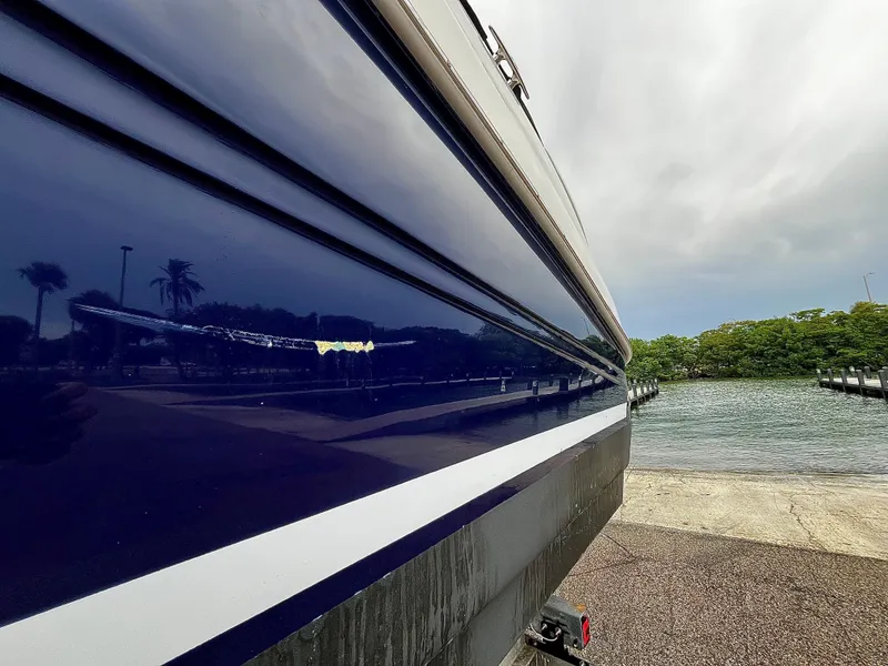 Slide: The Image of 2005 Sea Ray 280 Sundancer boat at dockside, reflecting trees and sky. - 14