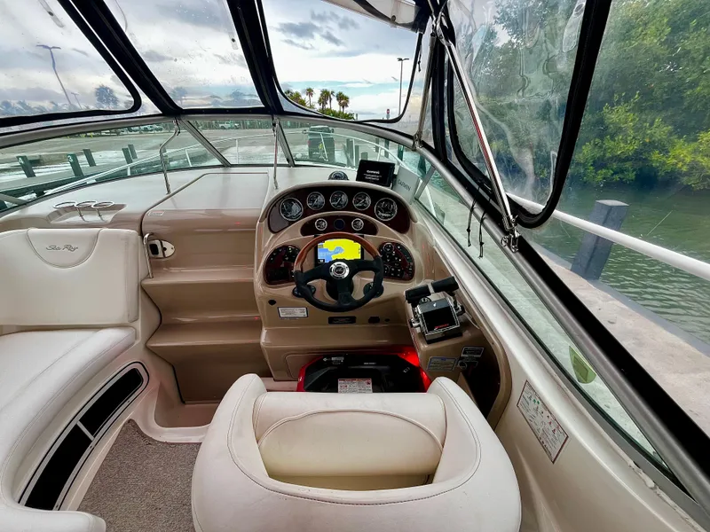 Slide: The Image of 2005 Sea Ray 280 Sundancer cockpit with steering wheel, gauges, and comfortable seating. - 30