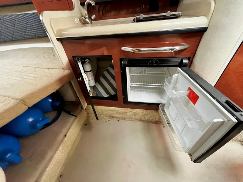 Slide: The Image of 2005 Sea Ray 280 Sundancer interior with open mini fridge and sink. - 38