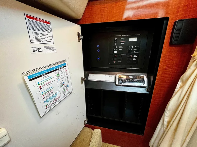 Slide: The Image of Electrical panel inside 2005 Sea Ray 280 Sundancer boat, featuring control switches and safety instructions. - 39