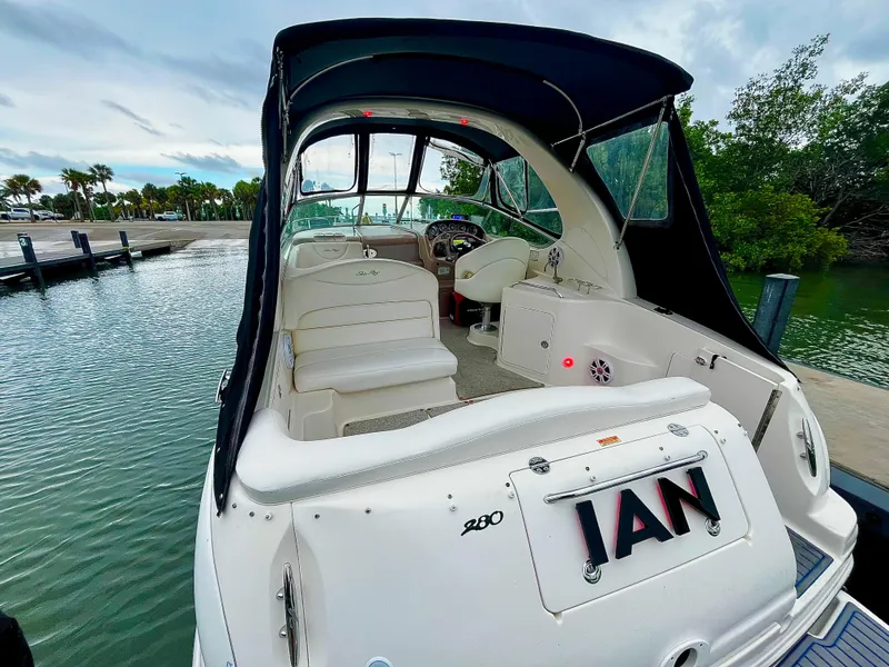 Slide: The Image of 2005 Sea Ray 280 Sundancer boat docked, featuring spacious cockpit and canopy. - 40