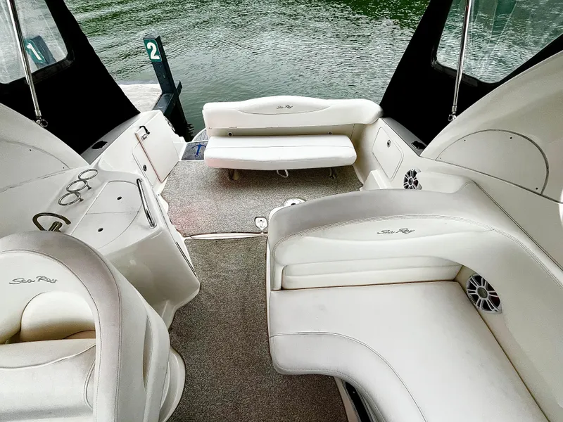 Slide: The Image of 2005 Sea Ray 280 Sundancer boat interior with white seating and lake view. - 44