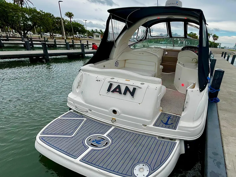 Slide: The Image of 2005 Sea Ray 280 Sundancer docked, rear view with open cockpit and custom flooring. - 46