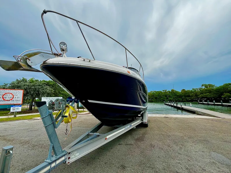 Slide: The Image of 2005 Sea Ray 280 Sundancer on trailer by waterfront, cloudy sky background. - 7
