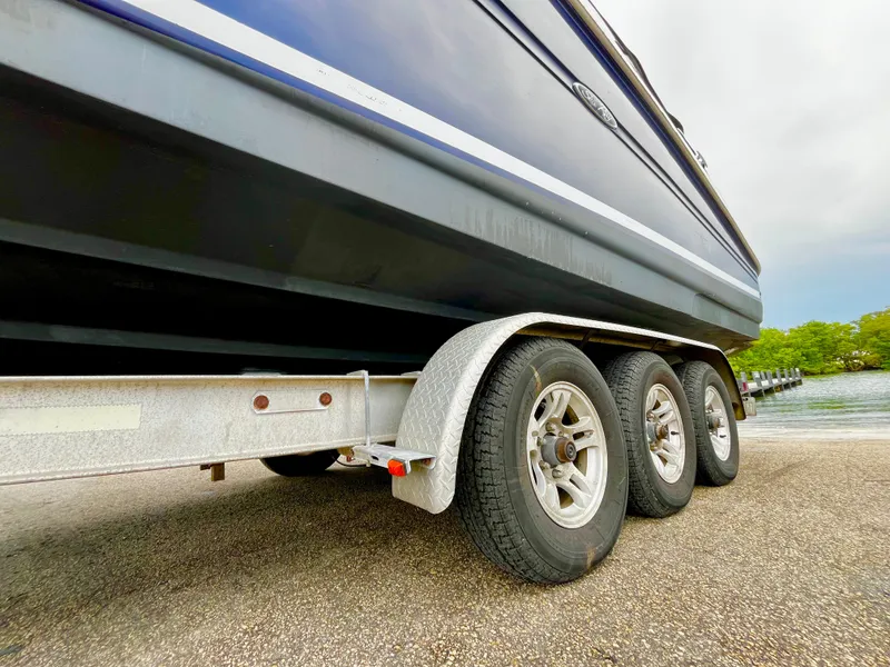 Slide: The Image of 2005 Sea Ray 280 Sundancer on trailer near water, showcasing triple-axle wheels. - 8