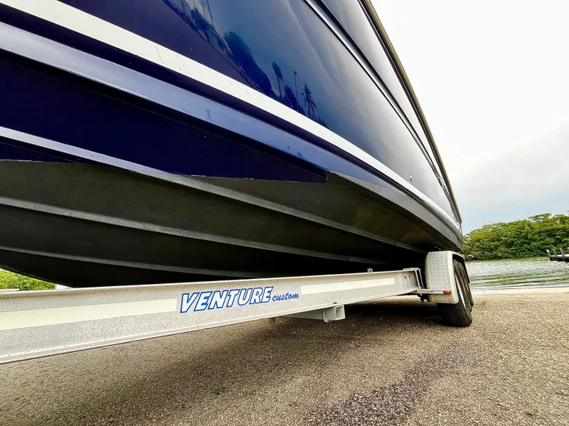 Slide: The Image of 2005 Sea Ray 280 Sundancer on Venture trailer near water, showcasing boat hull design. - 9