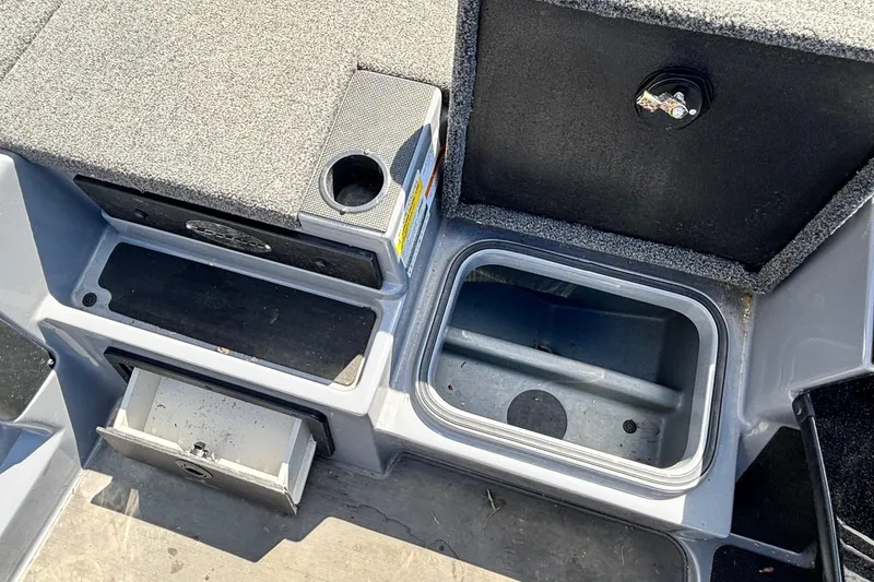 Slide: The Image of 2024 Triton 19 TrX boat storage compartments and cup holder, showcasing interior design features. - 10
