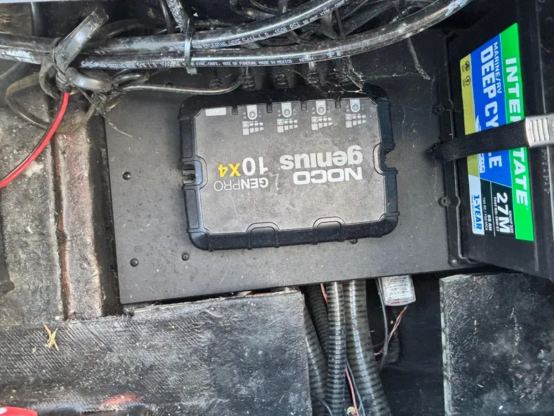 Slide: The Image of Battery compartment of a 2024 Triton 19 TrX with NOCO Genius GENPRO 10x4 charger. - 14
