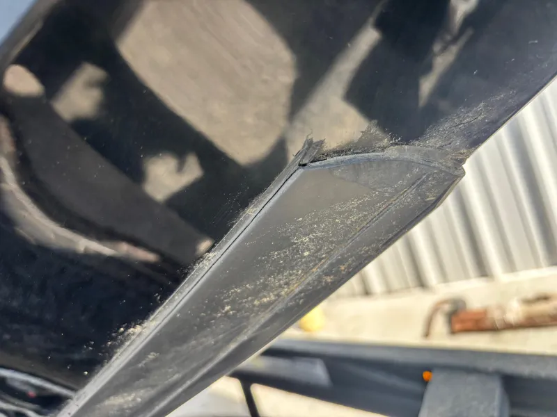 Slide: The Image of Close-up of a damaged edge on a 2024 Triton 19 TrX boat hull. - 2