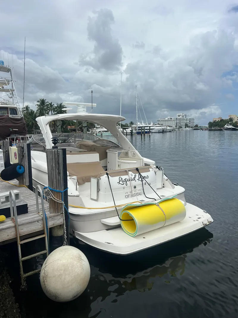 Slide: The Image of 2003 Regal Commodore 4260 yacht docked by a marina under cloudy skies. - 10