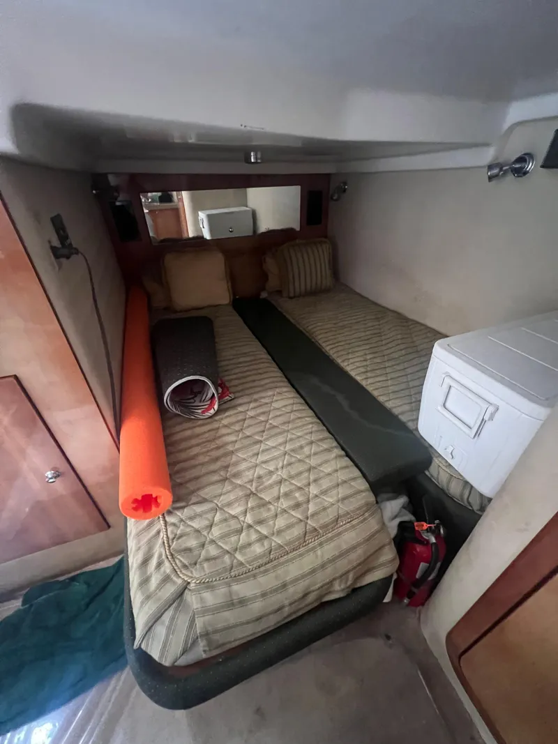 Slide: The Image of 2003 Regal Commodore 4260 cabin interior with bed, cooler, and storage. - 12