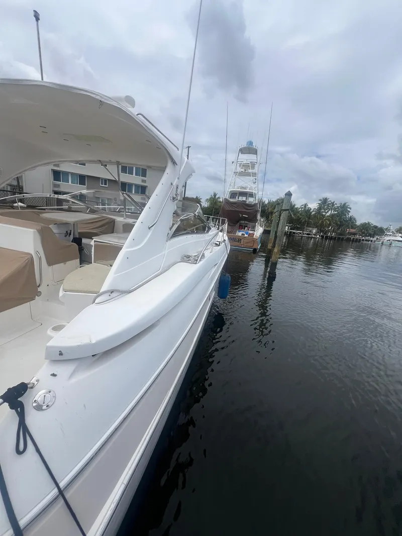Slide: The Image of 2003 Regal Commodore 4260 yacht docked at marina under cloudy sky. - 19