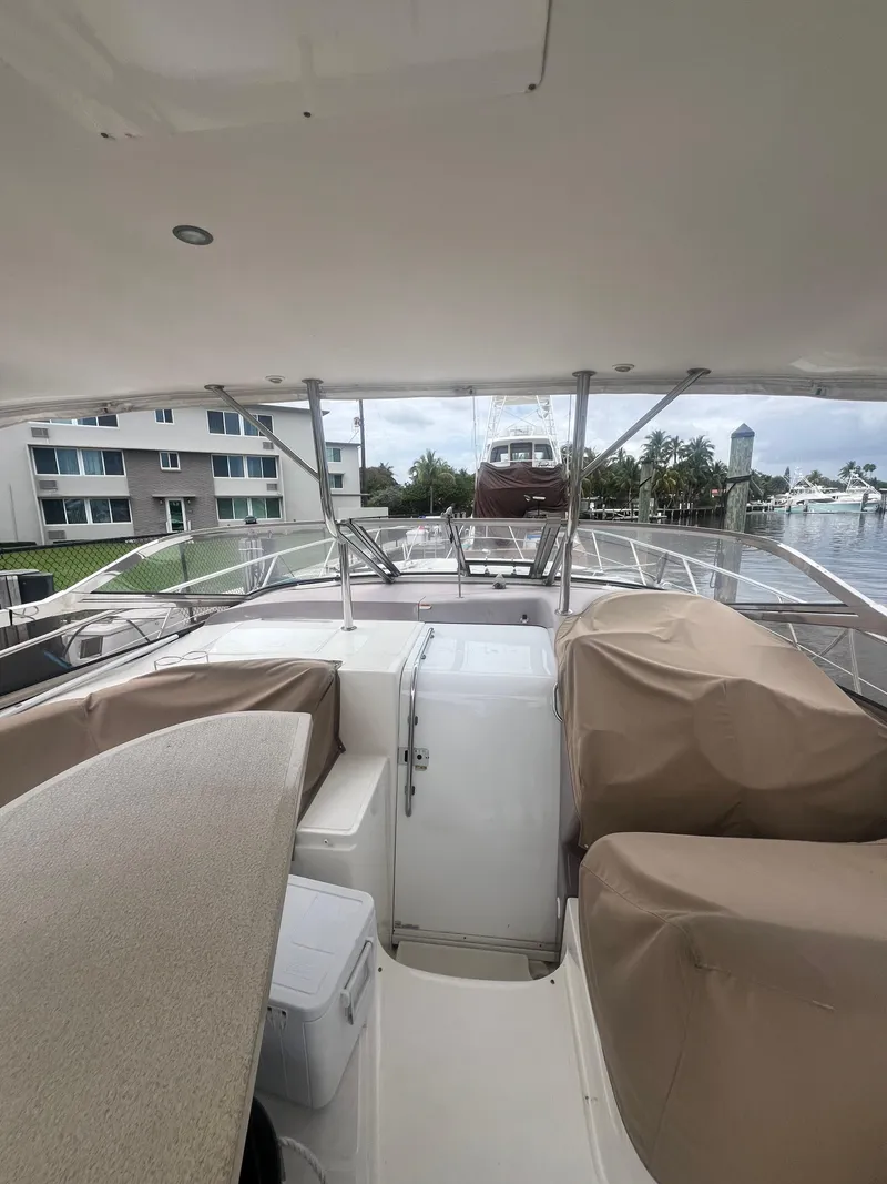 Slide: The Image of 2003 Regal Commodore 4260 yacht interior with covered seating and marina view. - 22
