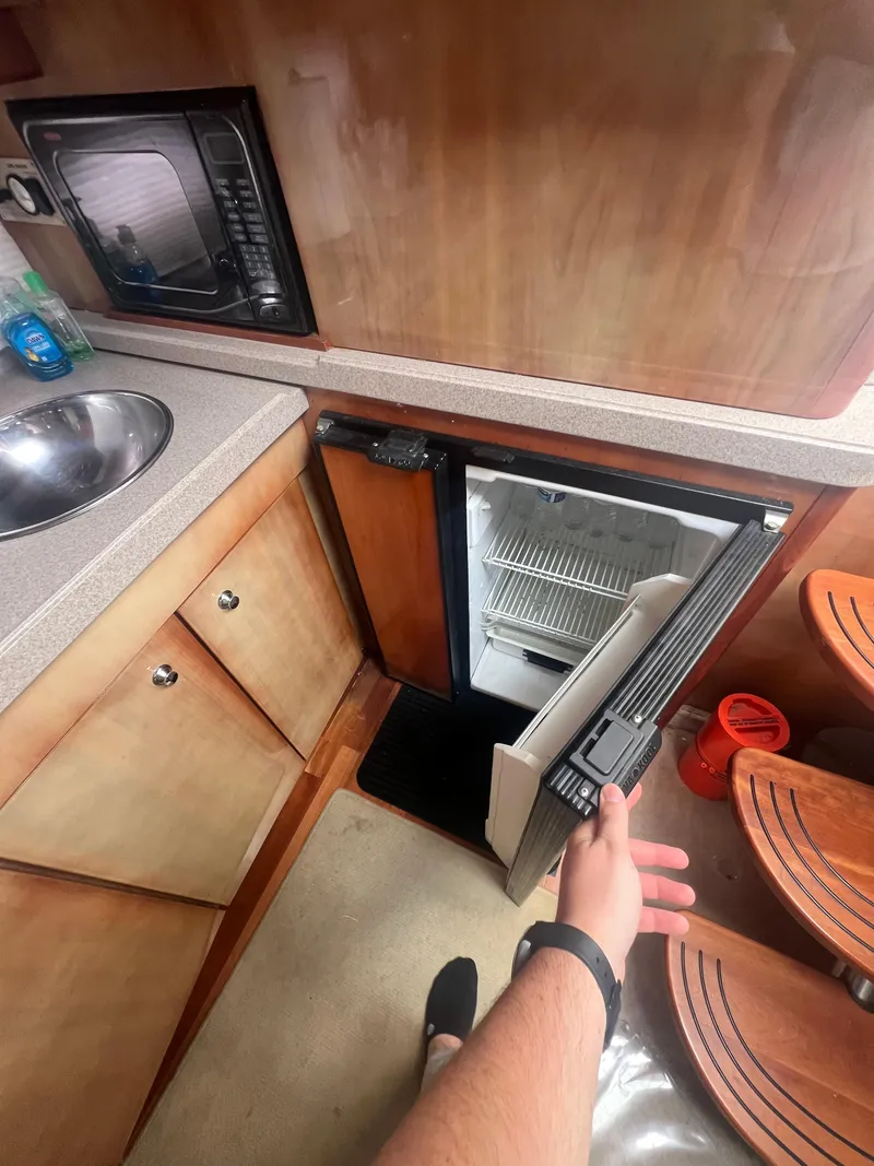 Slide: The Image of Interior of 2003 Regal Commodore 4260 yacht with open mini fridge and kitchenette. - 24
