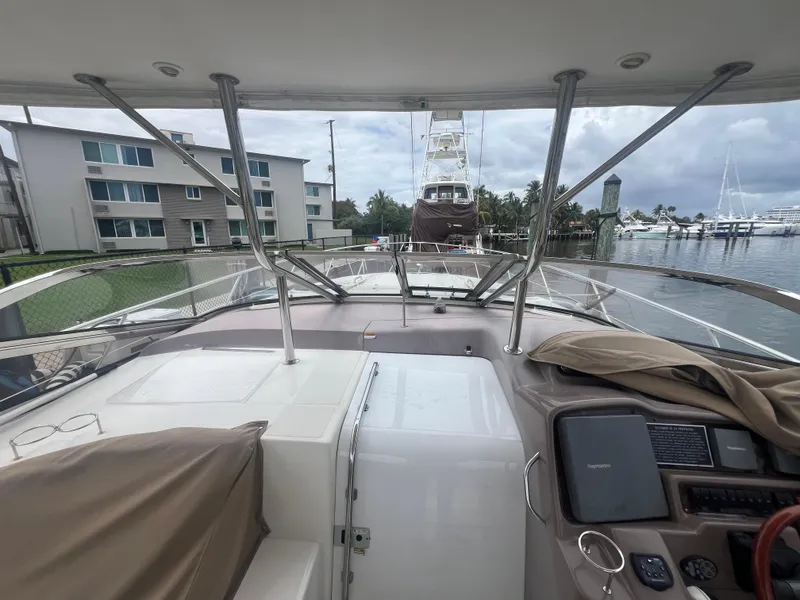 Slide: The Image of 2003 Regal Commodore 4260 yacht docked at marina with overcast sky. - 44