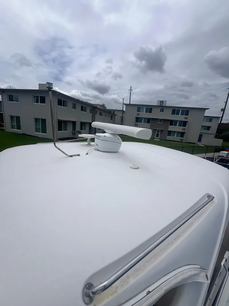 Slide: The Image of 2003 Regal Commodore 4260 yacht radar on deck, with cloudy sky and buildings in background. - 53