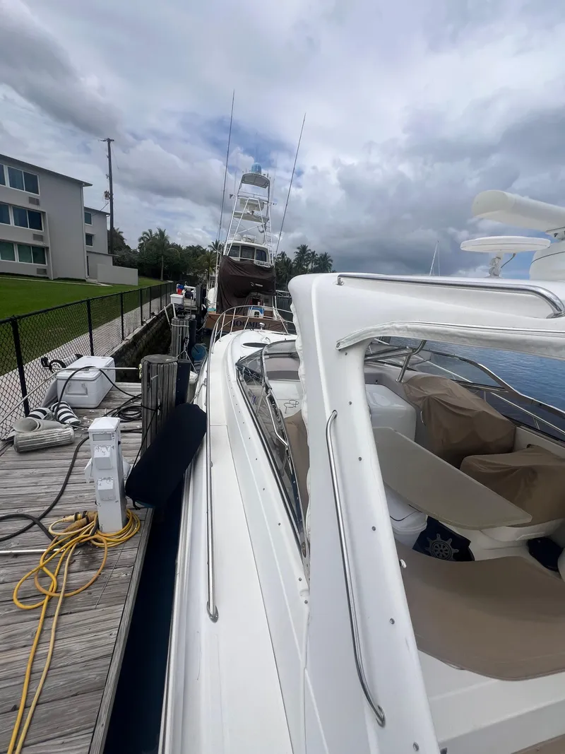 Slide: The Image of 2003 Regal Commodore 4260 yacht docked, with cloudy sky and nearby buildings. - 57