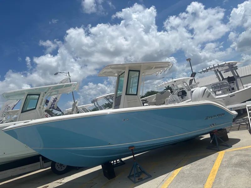 The Image of 2026 Sailfish 232 CC boat in light blue, displayed outdoors under a cloudy sky. - 1