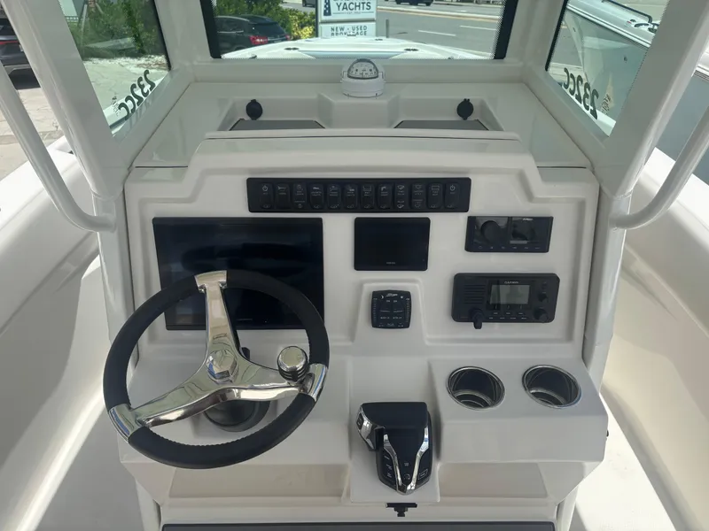 Slide: The Image of 2026 Sailfish 232 CC boat dashboard with steering wheel, controls, and navigation equipment. - 11