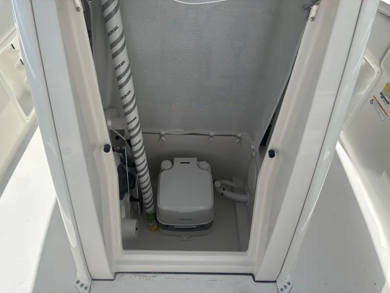 Slide: The Image of 2026 Sailfish 232 CC boat interior with portable toilet and storage compartment. - 15