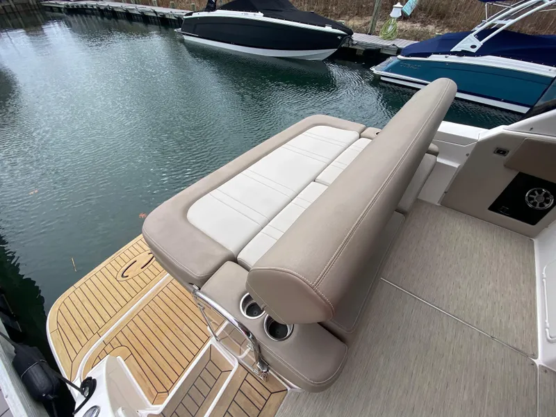 Slide: The Image of 2015 Regal 32 Express boat with beige seating and wooden deck by the water. - 11