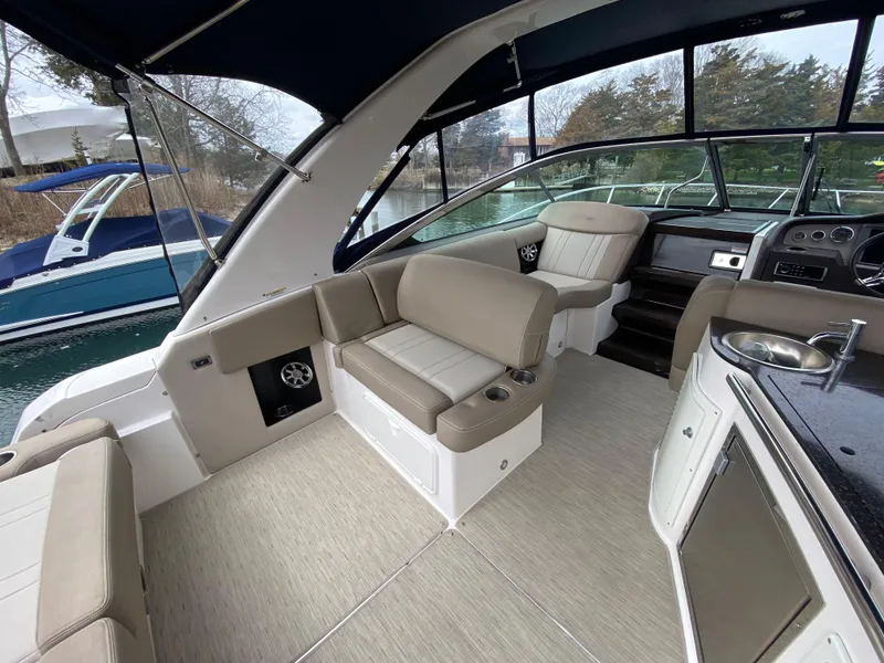 Slide: The Image of 2015 Regal 32 Express boat interior with beige seating and modern amenities. - 18
