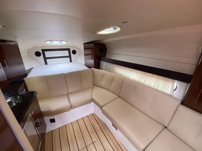 Slide: The Image of Interior of 2015 Regal 32 Express boat with beige seating and wood flooring. - 21