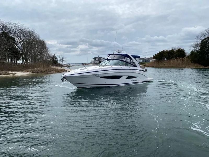 Slide: The Image of 2015 Regal 32 Express boat cruising on a calm waterway under cloudy skies. - 3