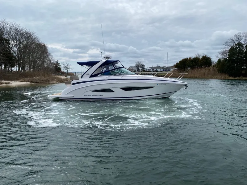 Slide: The Image of 2015 Regal 32 Express boat cruising on a calm, scenic waterway. - 7