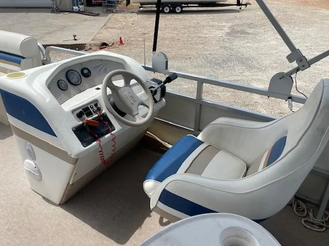 Slide: The Image of 1999 Sylvan 20 Elite boat cockpit with steering wheel and control panel. - 11