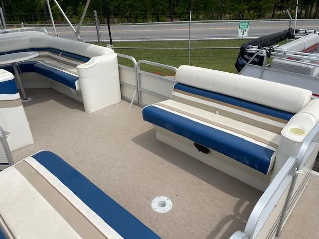Slide: The Image of 1999 Sylvan 20 Elite pontoon boat interior with blue and white seating. - 8