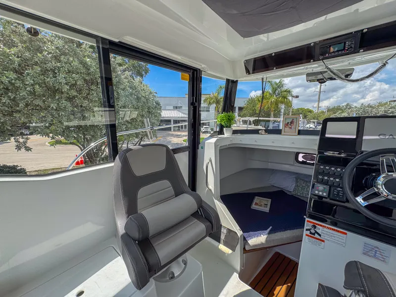 Slide: The Image of Interior of 2022 Jeanneau NC795 Sport boat with helm, seating, and cabin view. - 14