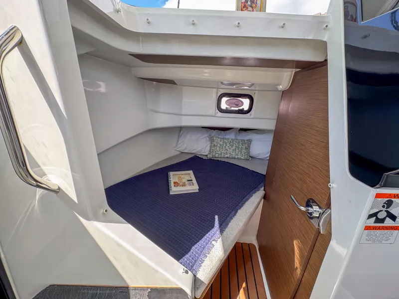 Slide: The Image of 2022 Jeanneau NC795 Sport cabin interior with cozy bed and window view. - 18