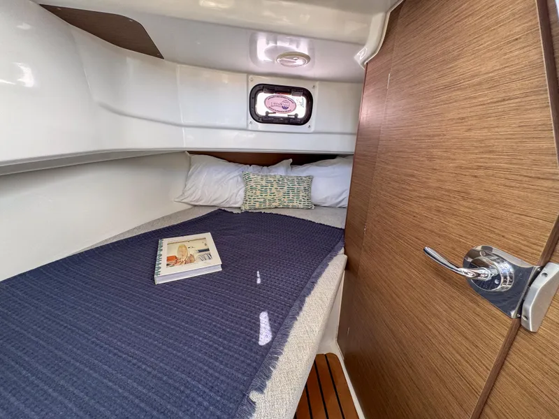 Slide: The Image of 2022 Jeanneau NC795 Sport cabin interior with cozy bed and wooden accents. - 20