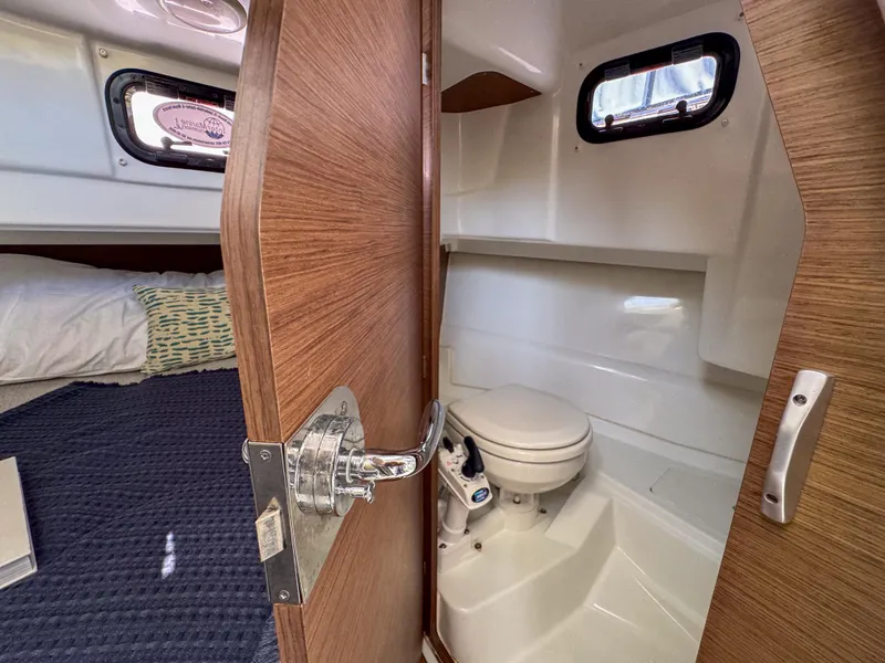 Slide: The Image of 2022 Jeanneau NC795 Sport cabin interior with bed and compact bathroom. - 21