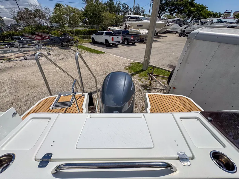 Slide: The Image of 2022 Jeanneau NC795 Sport boat with outboard motor, docked in a marina. - 25