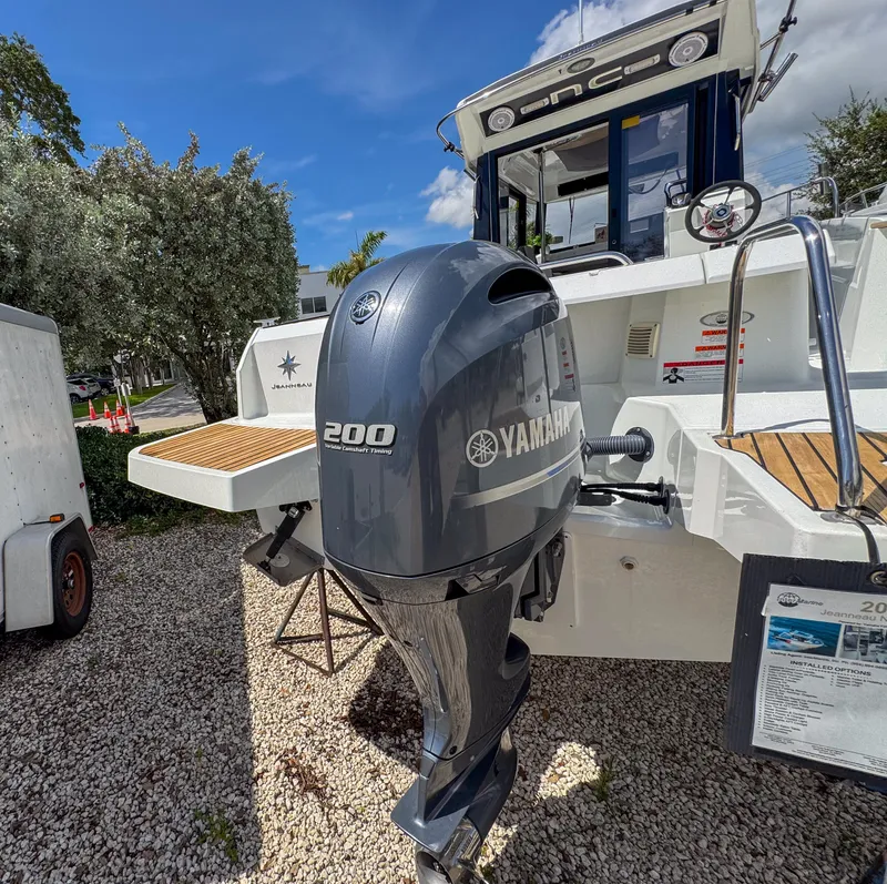 Slide: The Image of 2022 Jeanneau NC795 Sport with Yamaha 200 outboard motor, parked on gravel. - 26