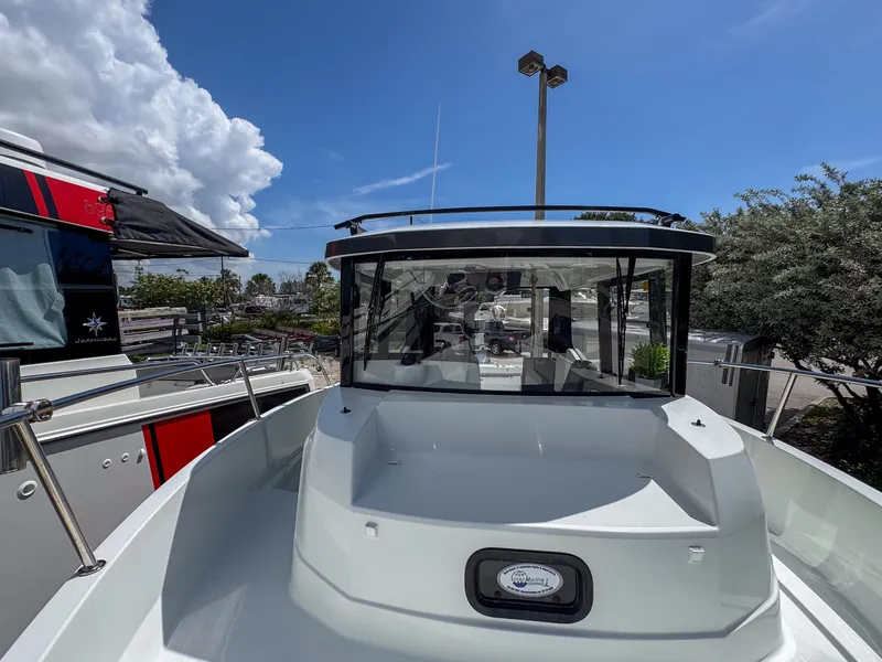 Slide: The Image of 2022 Jeanneau NC795 Sport boat, docked under a clear blue sky. - 27