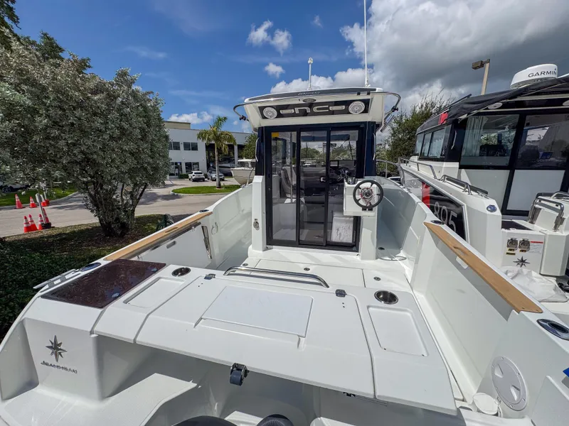 Slide: The Image of 2022 Jeanneau NC795 Sport boat, rear view, docked under a clear blue sky. - 5