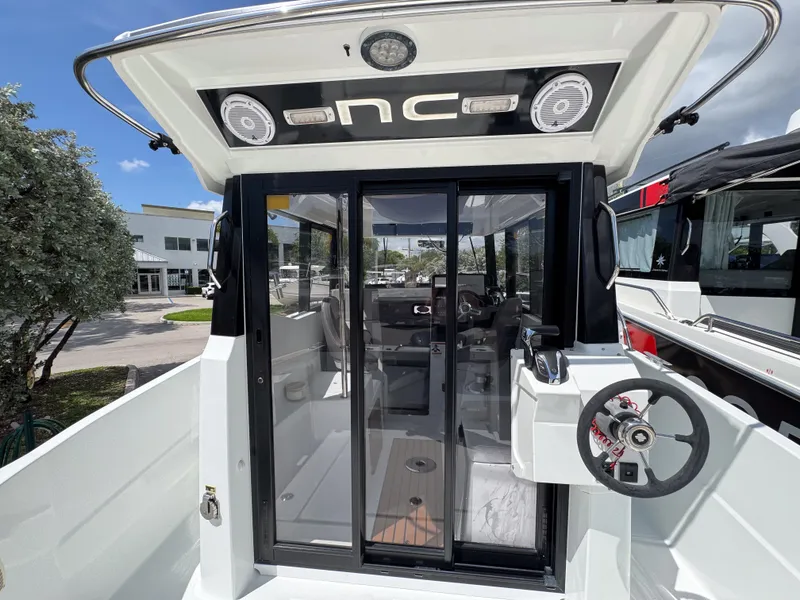 Slide: The Image of 2022 Jeanneau NC795 Sport boat cockpit with glass doors and steering wheel. - 7