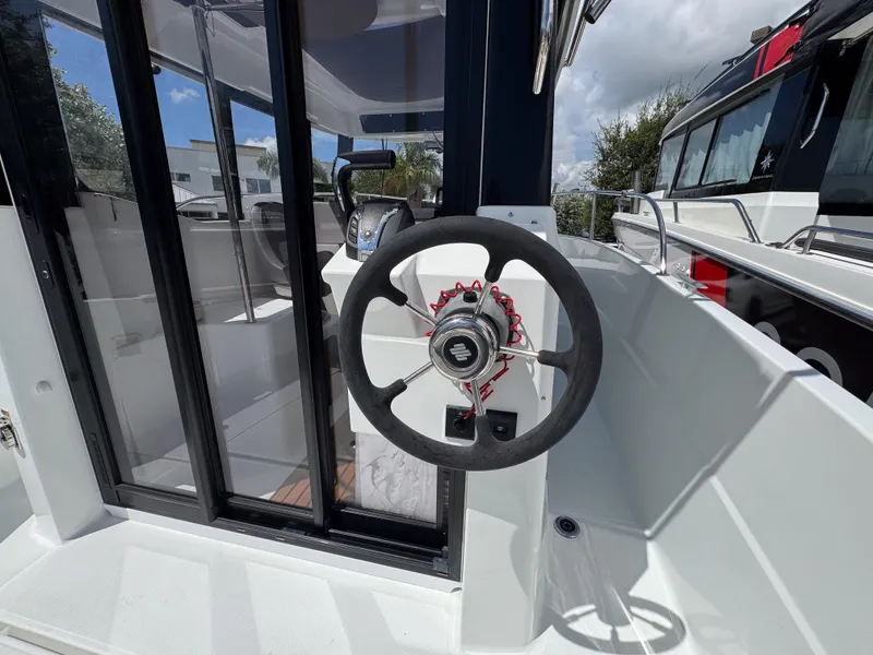 Slide: The Image of Steering wheel of 2022 Jeanneau NC795 Sport boat, showcasing modern design and controls. - 8