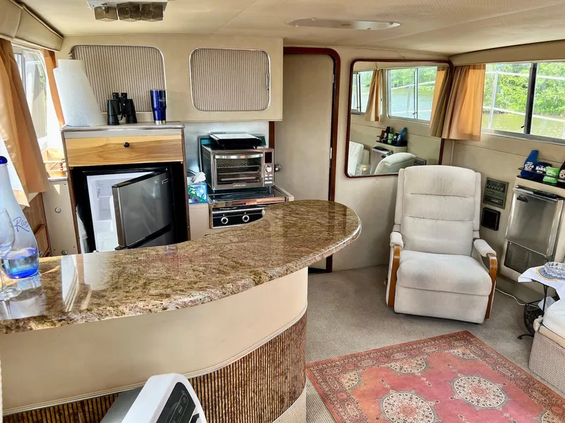Slide: The Image of 1986 Chris-Craft 381 Catalina interior with kitchen, seating, and windows. - 11
