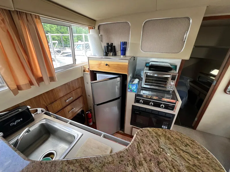 Slide: The Image of 1986 Chris-Craft 381 Catalina kitchen with sink, fridge, oven, and countertop. - 12