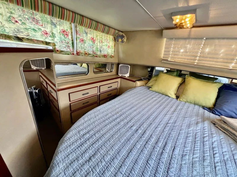 Slide: The Image of Cozy bedroom interior of 1986 Chris-Craft 381 Catalina yacht with floral curtains and plush bedding. - 14